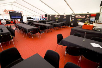 Erleben Sie eine einzigartige Fahrerlagereinrichtung im Cateringbereich mit dem hochwertigen EXPO-tent Zeltboden in Rot! Verleihen Sie Ihrer Veranstaltung einen festlichen und stilvollen Touch und erfreuen Sie sich an der erstklassigen Qualität und den ex